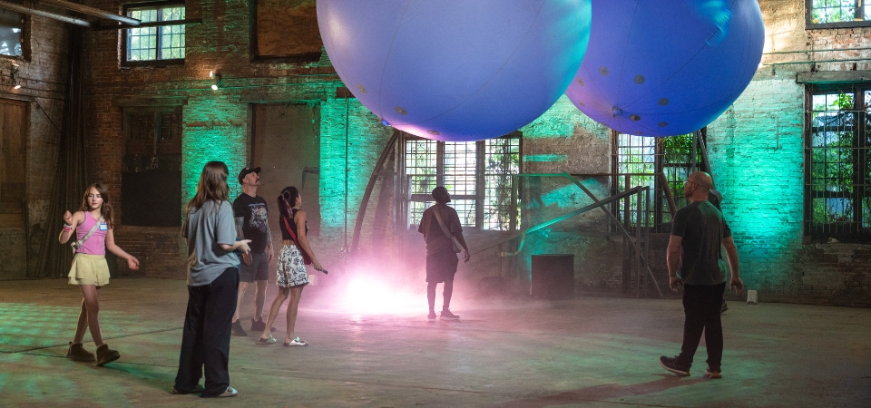 "Sound Clouds," an AI-powered interactive exhibit in which users shape the soundscape by interacting with inflatable spheres, was displayed at the Goat Farm in Atlanta on April 29, 2025. The work is a project of the Expressive Machinery Lab, run by Regents' Professor Brian Magerko of the School of Literature, Media, and Communication.